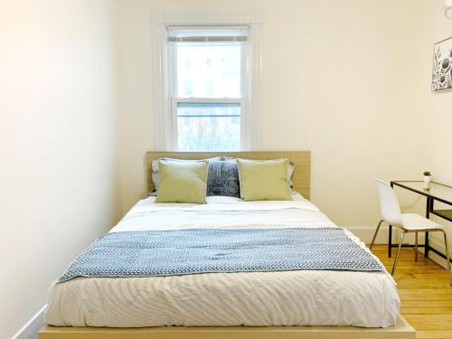 剑桥4 Bedroom Condo At Harvard Square and Harvard University的一间卧室配有一张带书桌的床和窗户。