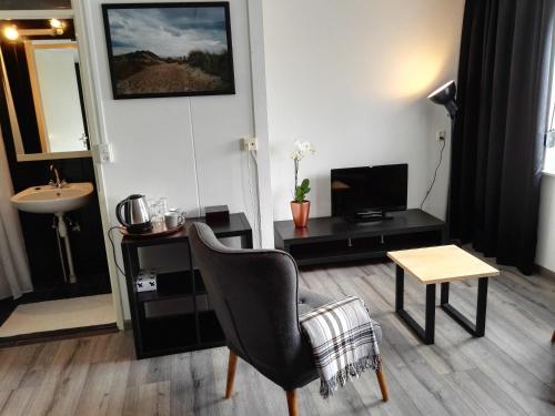 塞罗斯凯尔克Bed & Breakfast Carpe Diem Zeeland的客厅配有椅子和桌子