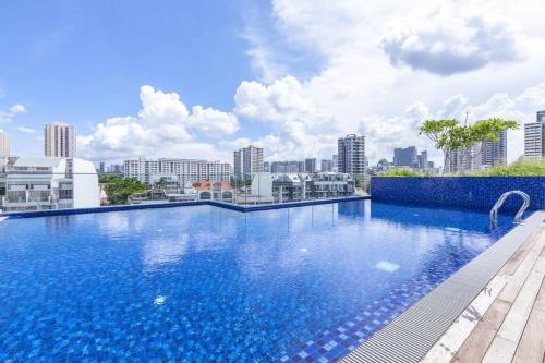 新加坡Centralize Stylish Loft Apartment Near MRT 市中心全景屋的一座大型蓝色游泳池,位于一座建筑的顶部