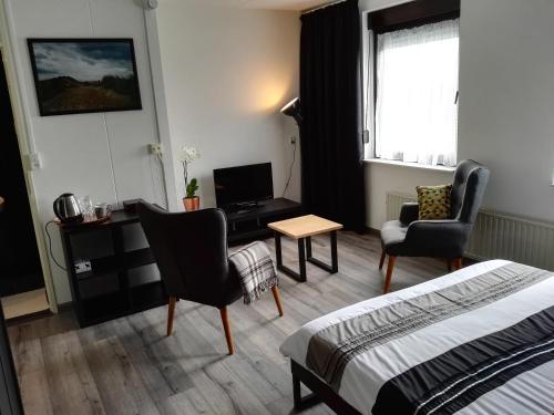 塞罗斯凯尔克Bed & Breakfast Carpe Diem Zeeland的酒店客房,配有一张床、一张桌子和椅子