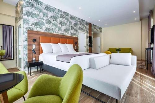 波尔多波尔多中心品质酒店的一间卧室配有一张大床和两把椅子