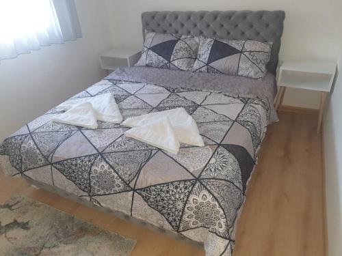 VrnjciSANI的一张带黑白棉被和枕头的床