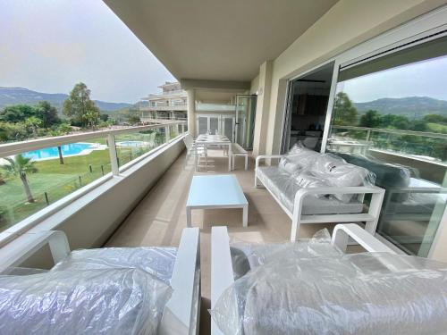 La MairenaLa Cala Golf - Luxury 3bed apartment - First line golf view的客房设有两张床和一个带游泳池的阳台。