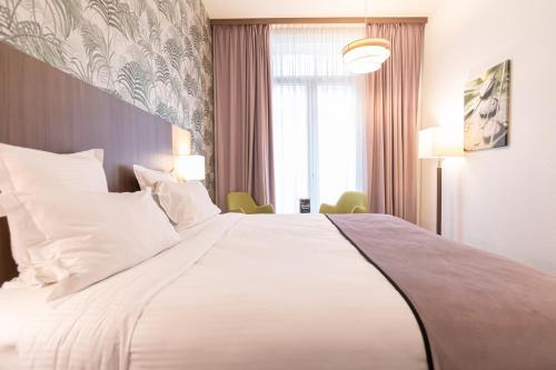 波尔多波尔多中心品质酒店的一张大白色的床,位于酒店客房内