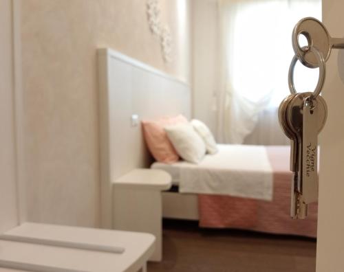 卡萨马塞拉Vigne Vecchie的卧室的钥匙,卧室配有一张床和一个窗户