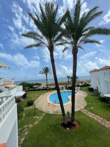 德尼亚Playa Del Sol, 1 dormitorio frente al mar, by Bookindenia的从棕榈树度假村的阳台可以欣赏到风景