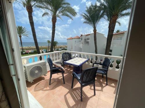德尼亚Playa Del Sol, 1 dormitorio frente al mar, by Bookindenia的阳台配有桌椅和棕榈树。