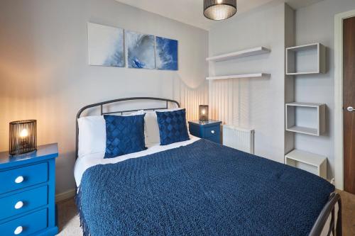 格拉斯哥Host & Stay - London Avenue的一间卧室配有蓝色的床和蓝色梳妆台
