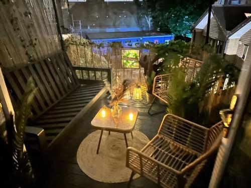 伦敦Beautiful haven,Tower Bridge Rd的庭院设有2张长椅和1张带灯的桌子。