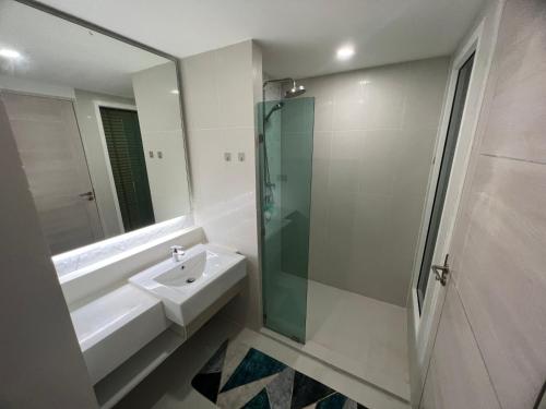 乔木提恩海滩Seven Seas Condo by MK的一间带水槽和玻璃淋浴的浴室