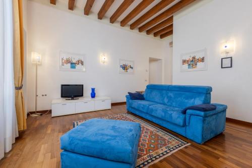 威尼斯科堤诺瓦酒店的客厅配有蓝色的沙发和电视