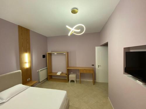 地拉那Hotel Kaloshi的一间卧室配有一张床、一张桌子和吊扇
