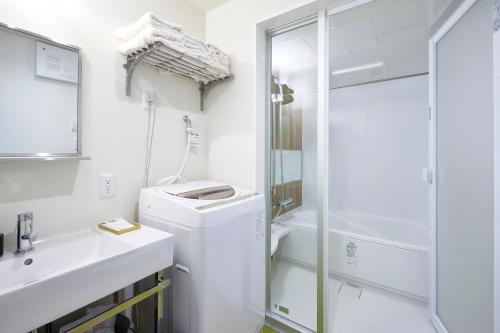 藤泽COFFEE HOTEL Soundwave的白色的浴室设有水槽和淋浴。