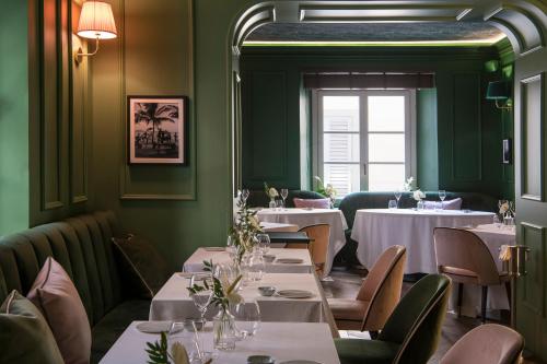 佛罗伦萨Hotel La Gemma的餐厅设有白色的桌椅和窗户。