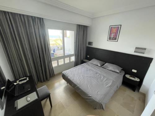 比塞大Beachfront Apartment 105- Hotel Andalucia的酒店客房设有床和窗户。