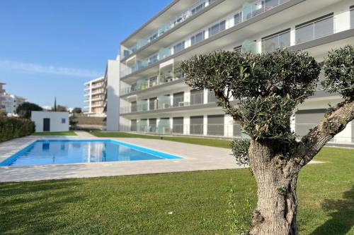 波尔蒂芒T2 Monte Residence by amcf的一座带游泳池的建筑前的树