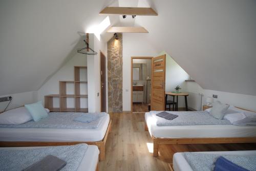什切尔克Ski House Szczyrk - Czyrna的带三张床和楼梯的房间