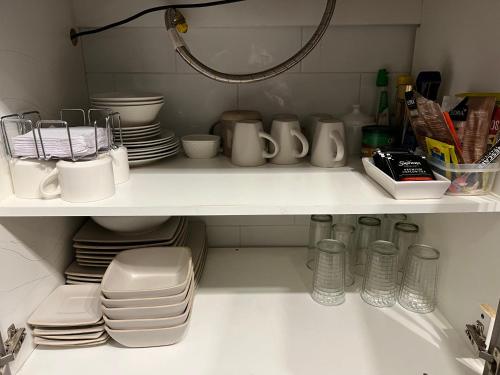 奇廉LETICE LODGE Chillán的厨房架子上摆放着盘子和盘子