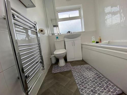 吉林汉姆Home in Medway的浴室配有卫生间、浴缸和水槽。