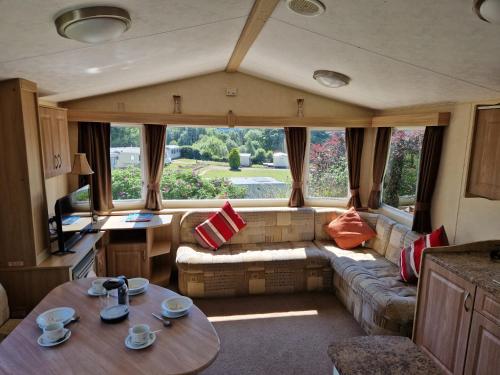 基林Cruachan Caravan and Camping Farm的一个带沙发和桌子的大篷车客厅