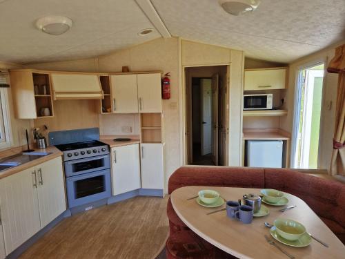 基林Cruachan Caravan and Camping Farm的一个带桌子的小篷车的小厨房