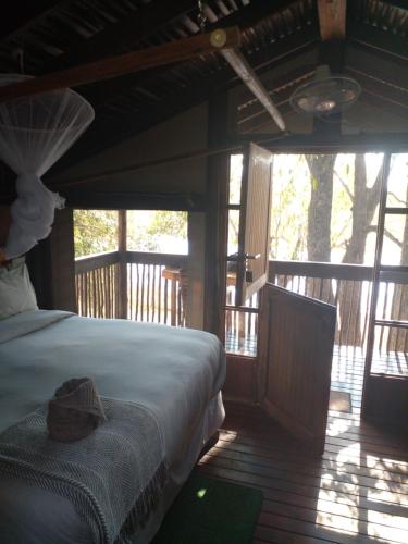 NtabisNako Okavango Guesthouse的一间卧室,配有一张床,上面有帽子