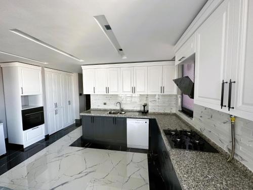 萨姆松B&C Luxury Residence的厨房配有白色橱柜和黑色台面
