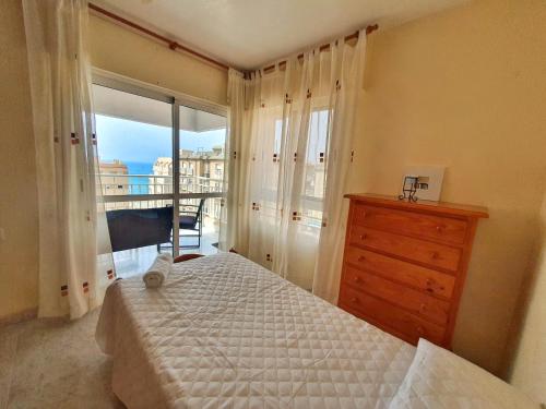 阿桂拉斯Vistas al mar con Aire Acondicionado y Parking - by Aloha Palma的一间卧室配有一张床、一个梳妆台和一扇窗户。