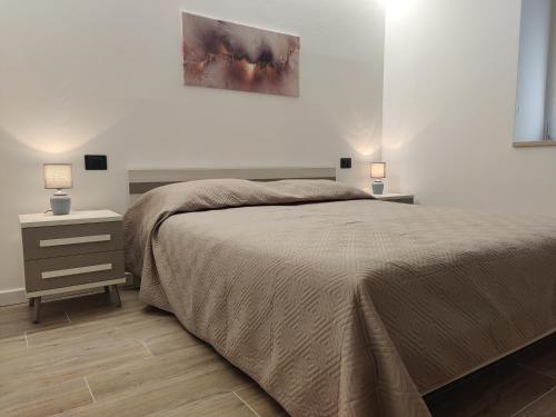 OspedalettoCasa Venere的一间卧室配有一张床和一个带两盏灯的床头柜。
