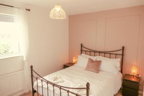 WarmleyHome in Longwell Green的一间卧室配有一张带白色床单和吊灯的床。
