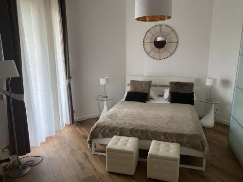 罗马Eur Centro lux apartment con camino的一间卧室配有一张带两张凳子和镜子的床