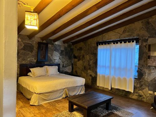 蒙特雷Hotel Chipinque的一间卧室设有一张床和石墙