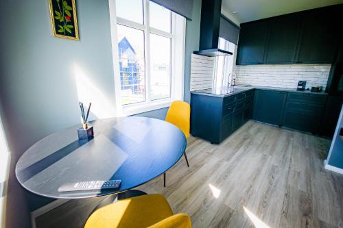 韦斯特曼纳埃亚尔Guesthouse Holl的厨房配有蓝色的桌子和黄色的椅子