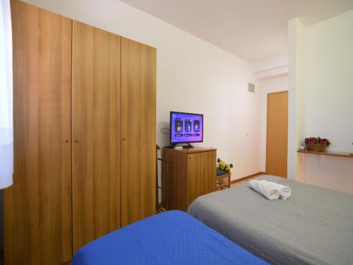 KaštelBassanese Kastel的一间卧室设有两张床,并在橱柜上配有电视。