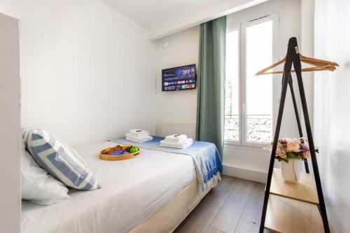 巴黎Résidence Beaugrenelle - Tour Eiffel 1的白色卧室设有一张带窗户的床