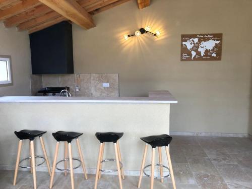 圣雷米普罗旺斯Superbe villa neuve à 5 mn du centre的厨房配有带四把吧台凳的吧台