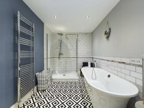 斯旺西-- Huge -- 5-bedroom home & Private Gym by Tailored Accommodation的设有带浴缸和淋浴的浴室。
