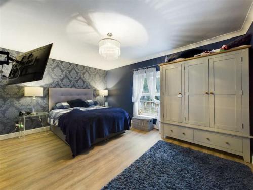 斯旺西-- Huge -- 5-bedroom home & Private Gym by Tailored Accommodation的一间卧室配有床、橱柜和地毯