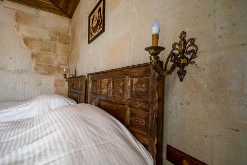 内夫谢希尔Cappadocia inans Cave & Swimming Pool Hot的一间卧室配有一张带木制床头板的床