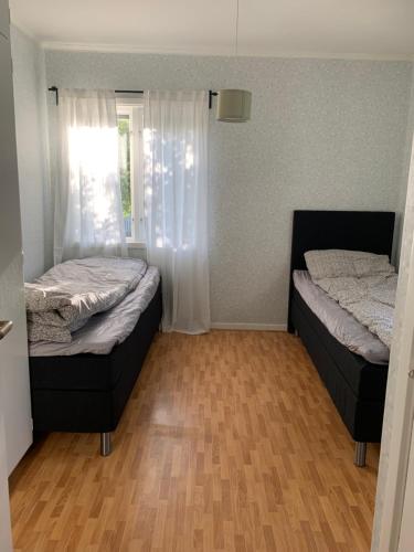 延雪平Lägenhet på Strömsholm的铺有木地板的小客房内的两张床