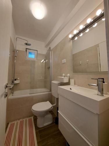 拉斯托伏Apartman Portorus的浴室配有卫生间、浴缸和水槽。
