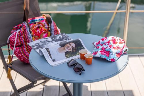 曼弗雷多尼亚Marina del Gargano Houseboat的桌子,桌子上放着书,袋子和眼镜