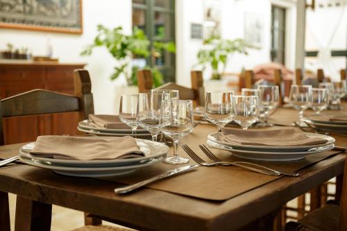 卡布拉斯Hotel Ristorante Sa Pedrera的一张木桌,上面放有盘子和酒杯