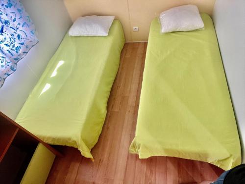 帕塔亚什Bumgalow 5X的配有黄色床单的客房内的两张床