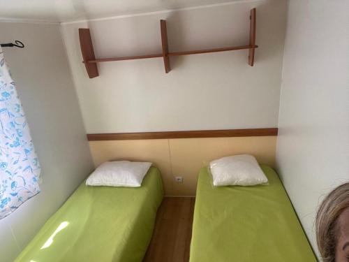 帕塔亚什Bumgalow 5X的一间小房间,里面设有两张绿色的床