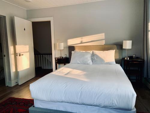 滨湖尼亚加拉South Landing Inn的卧室配有一张带白色床单和枕头的大床。