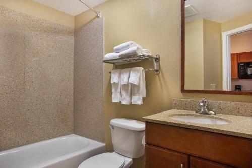 圣安东尼奥安东尼奥西南部烛木套房酒店（近海洋世界）的浴室配有卫生间、盥洗盆和浴缸。