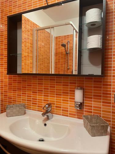 瓦伦纳Varenna by Foot (no Taxi / Car needed)的浴室水槽和橙色瓷砖墙