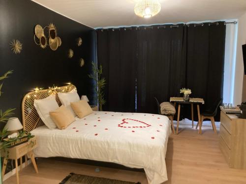 克雷伊Séduisant petit cocon的一间卧室,床上有红色的鲜花