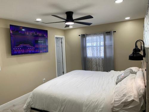 奥兰多Sunny days vacation rental LLC的卧室配有白色的床和吊扇
